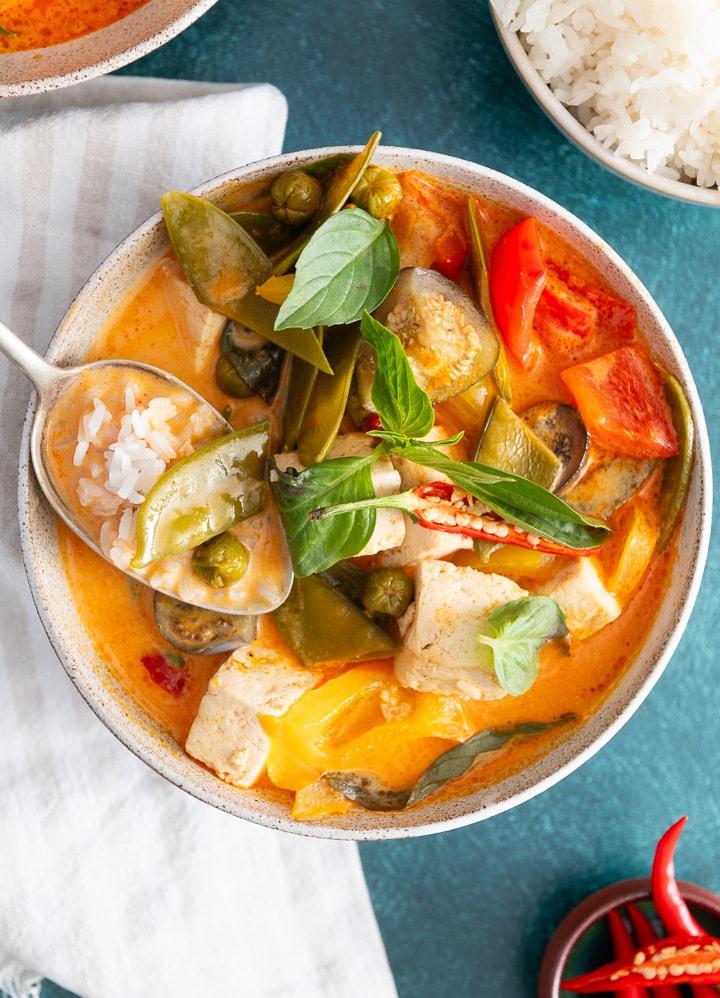 Ein Löffel nimmt Reis und rotes Thai Curry auf.