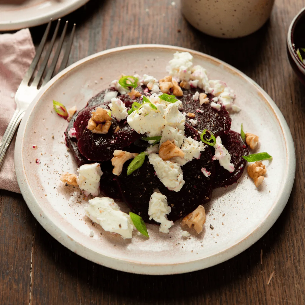 Rote Bete Salat roh mit Schafskäse auf dem Teller.