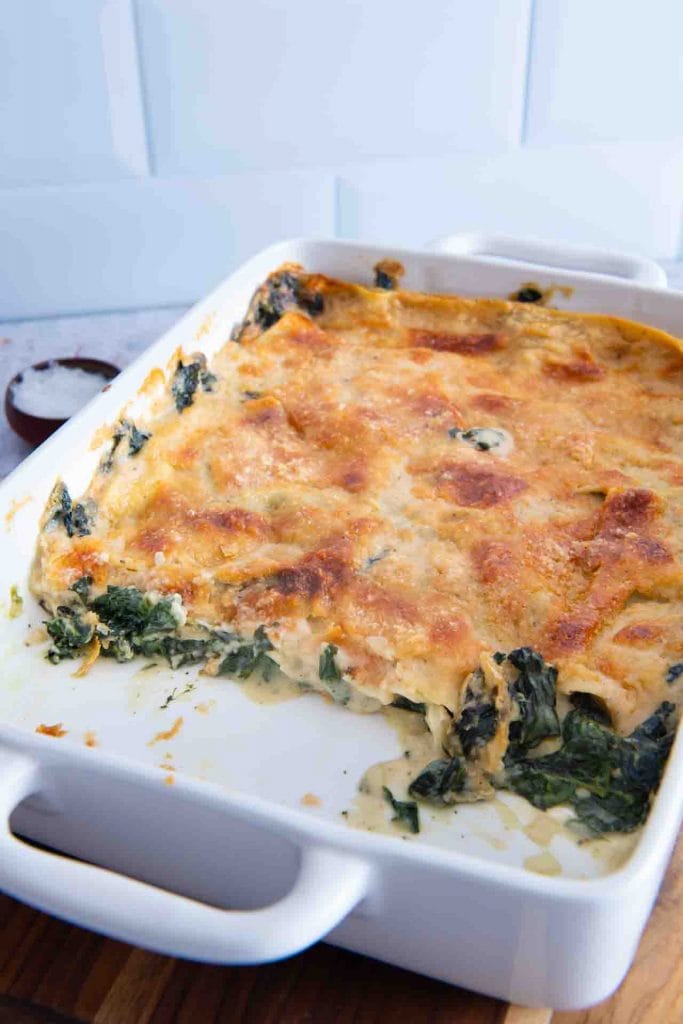 Eine angeschnittene Spinatlasagne vegetarisch, gefüllt mit Spinat.