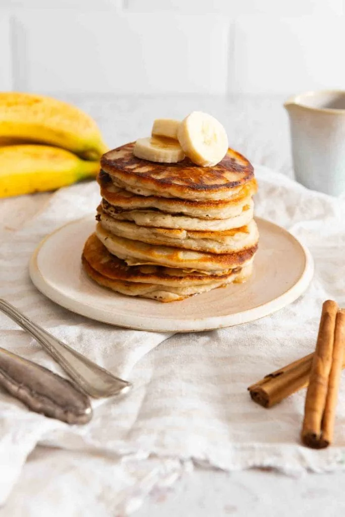 Bananen Pancakes ohne Ei liegen gestapelt auf einem Teller. 