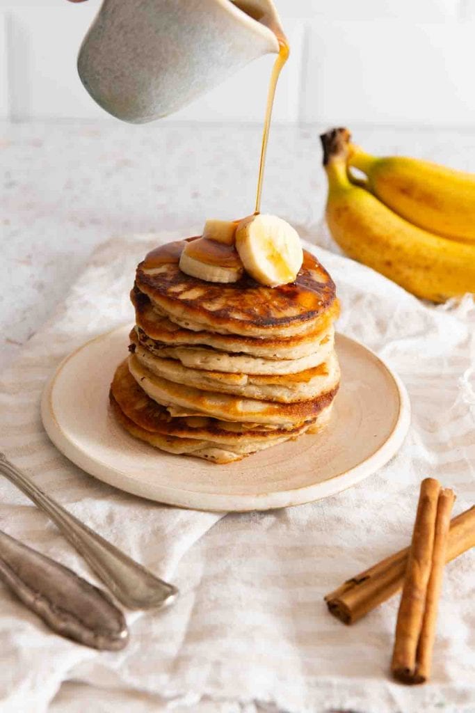 Ahornsirup wird über die Bananen Pancakes gegossen.