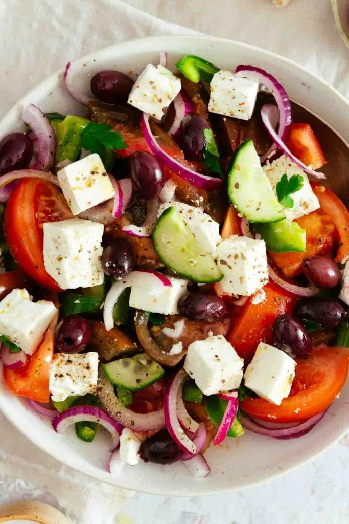 Der Griechischer Salat in der Nahaufnahme. Man erkennt Tomaten, Zwiebeln, Feta und Gurke.