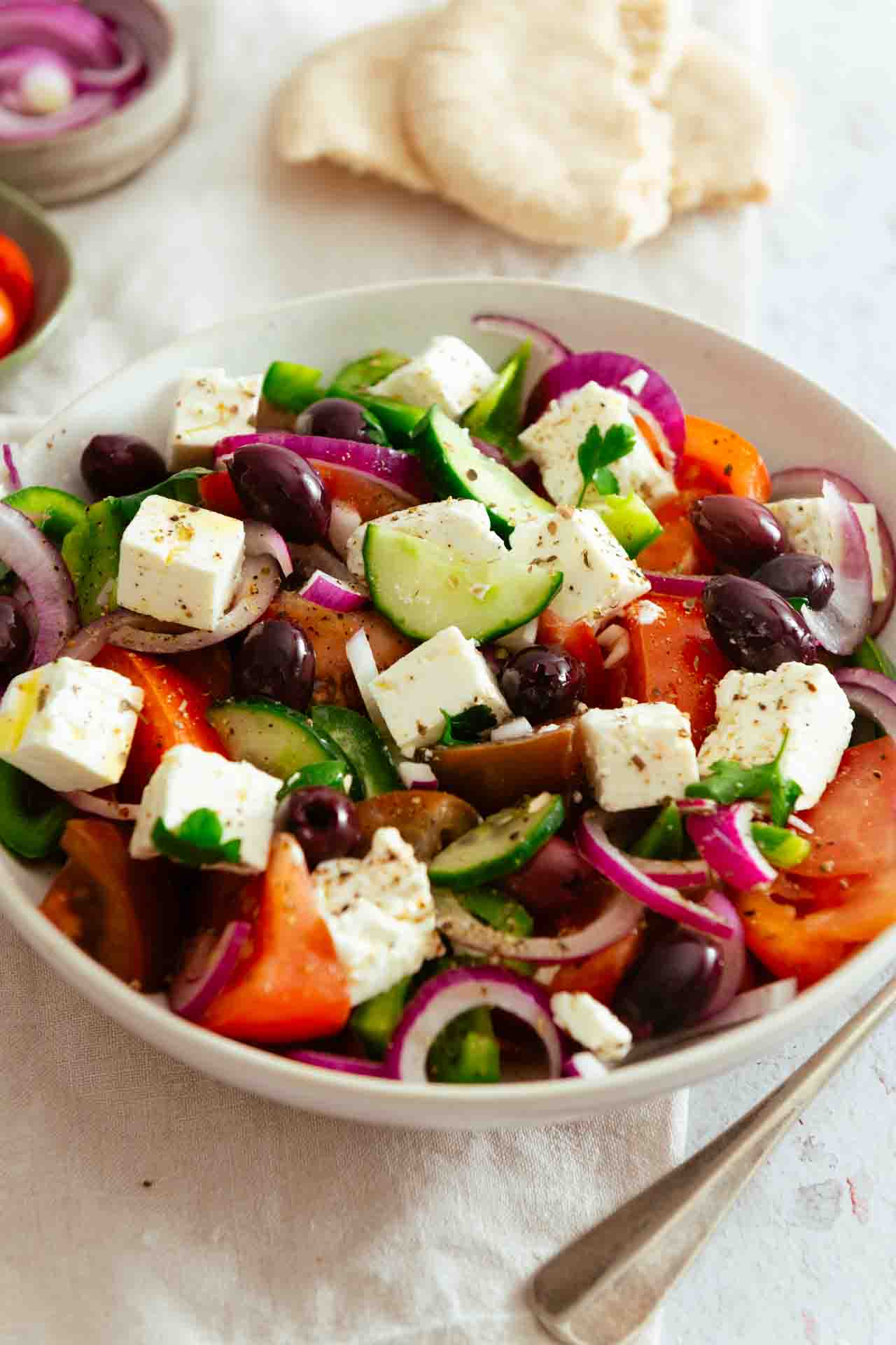 Ein Griechischer Salat mit Feta, daneben liegt ein Löffel.