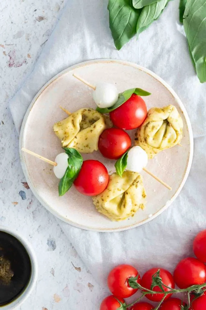 Die Fingerfood Tortellini bestehen aus Tortellini, Tomaten, Basilikum und Mozzarella.