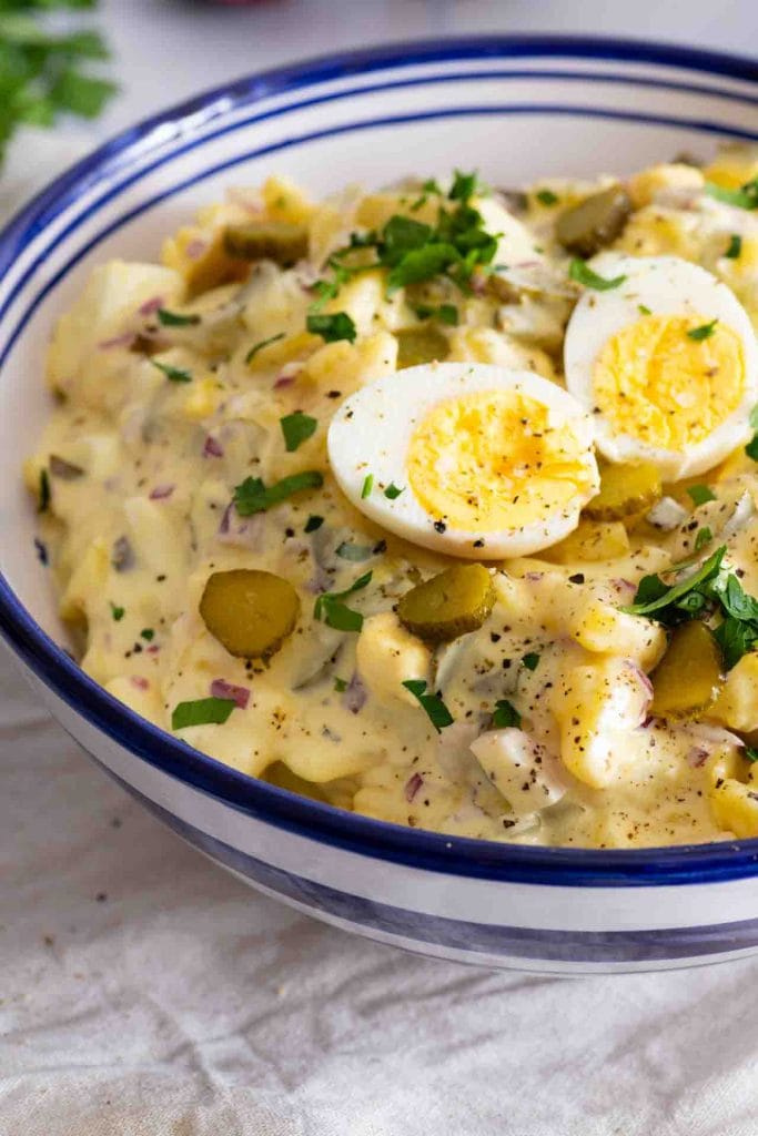 Ein Kartoffelsalat mit Mayo und zwei Eihälften oben drauf.