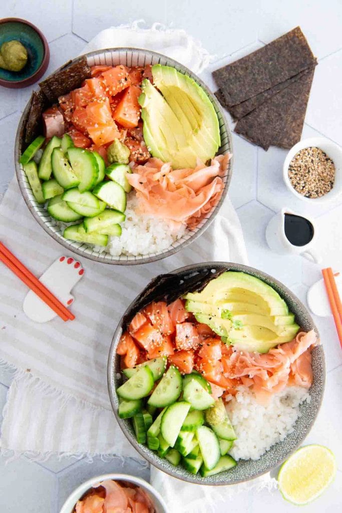 Zwei von den Sushi Bowls mit Stäbchen und Soja Sauce auf dem Tisch.