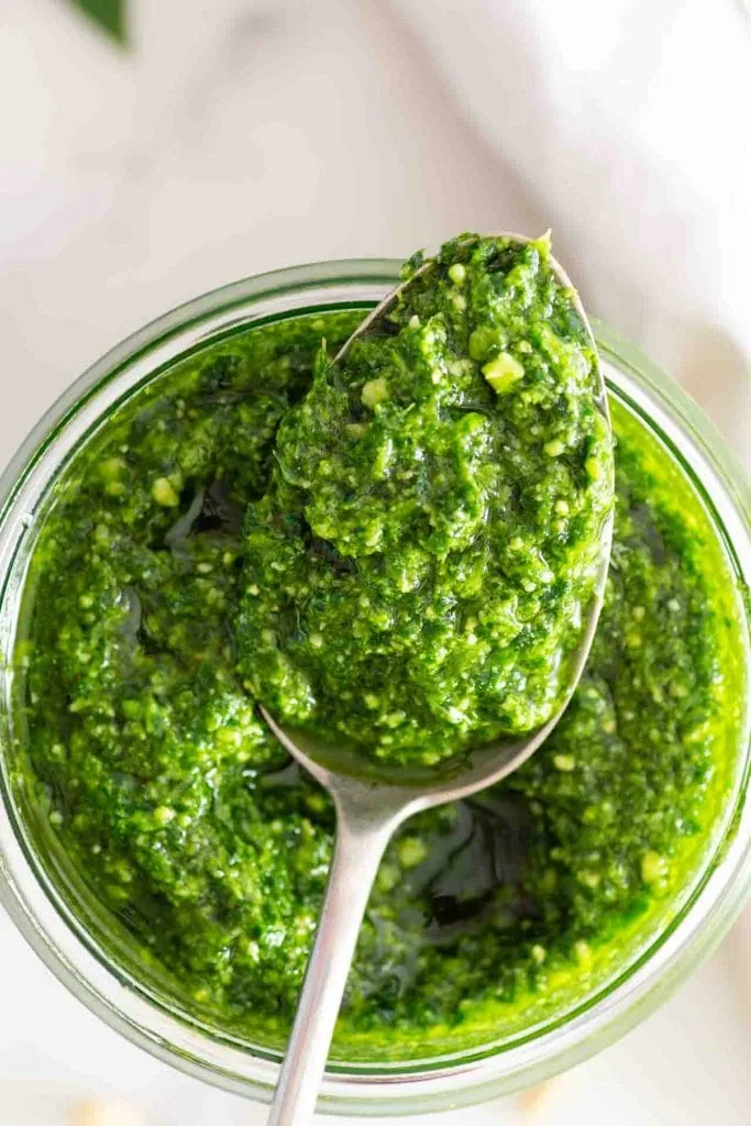 Ein Löffel nimmt etwas Bärlauchpesto auf.