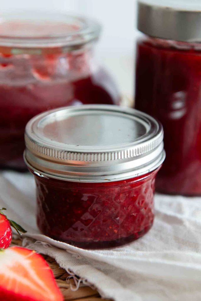 Ein Glas Erdbeermarmelade ohne Gelierzucker auf dem Tisch.