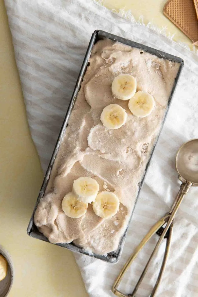 Das Bananeneis in einer Form mit Bananenscheiben als Deko.