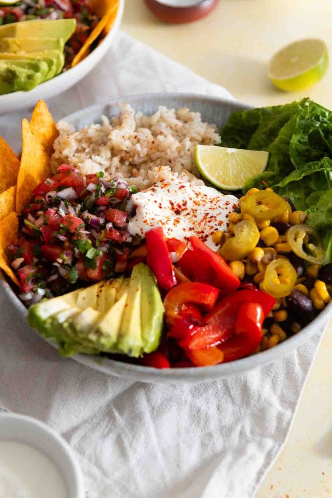 Eine Burrito Bowl auf dem Tisch, daneben liegt eine Limette.