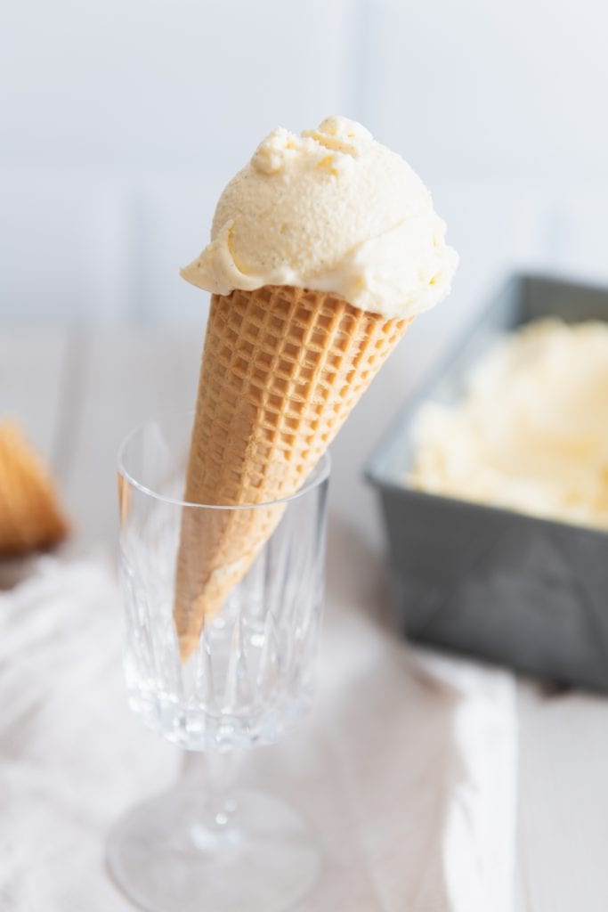 Eine Kugel Vanilleeis aus der Eismaschine auf einer Waffel.
