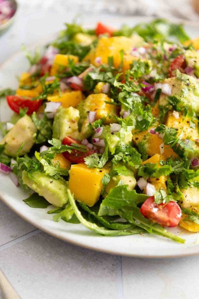 Der Salat mit Mango, Avocado und Tomaten von der Seite.
