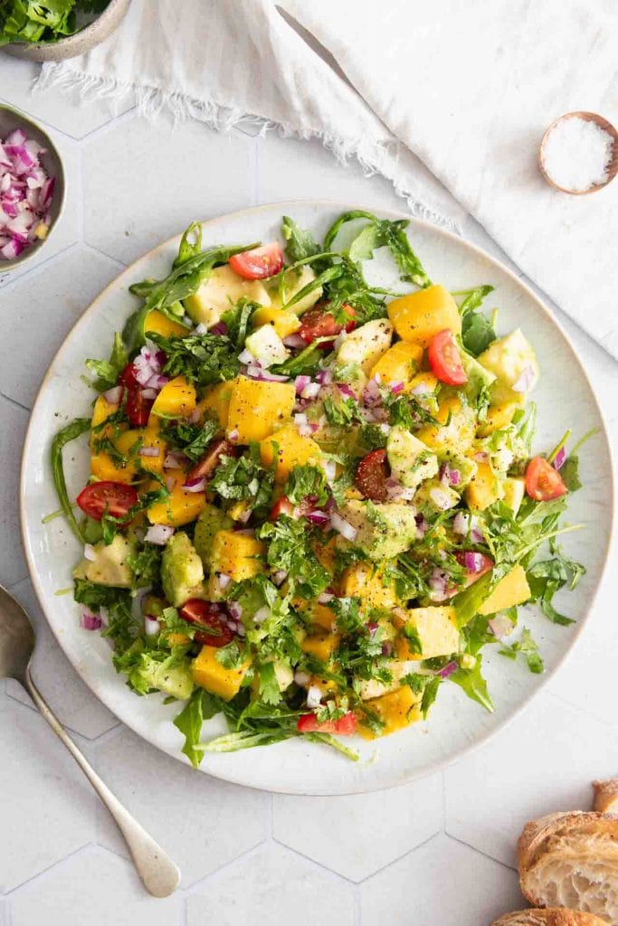 Der Avocado Mango Salat von oben auf dem Tisch mit Brot.