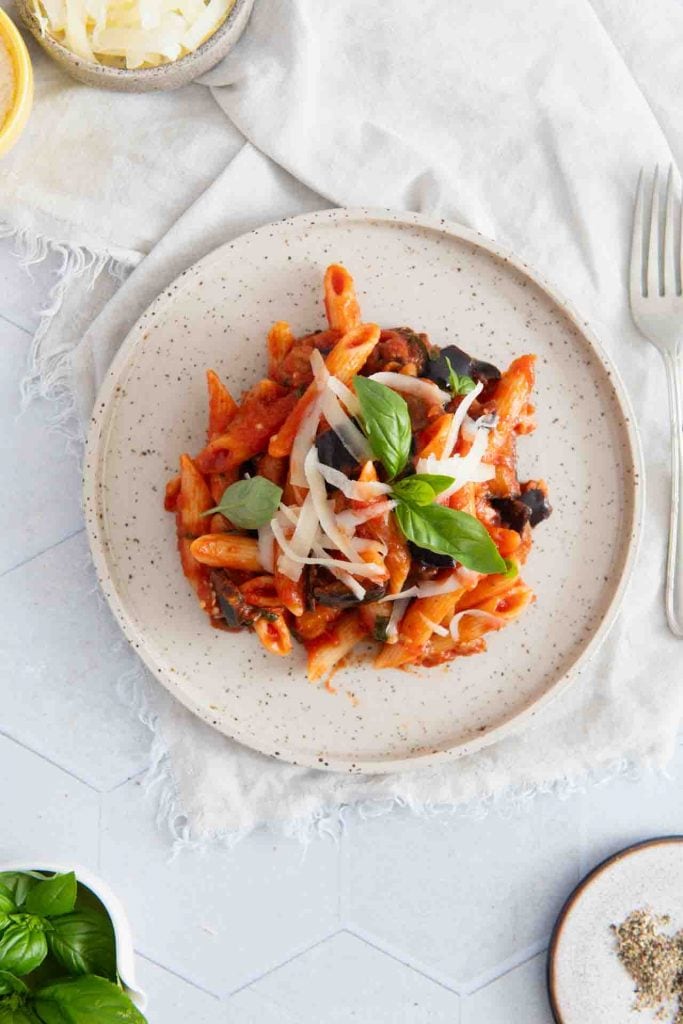Ein Teller mit der fertig gekochten Pasta und einer Gabel daneben.
