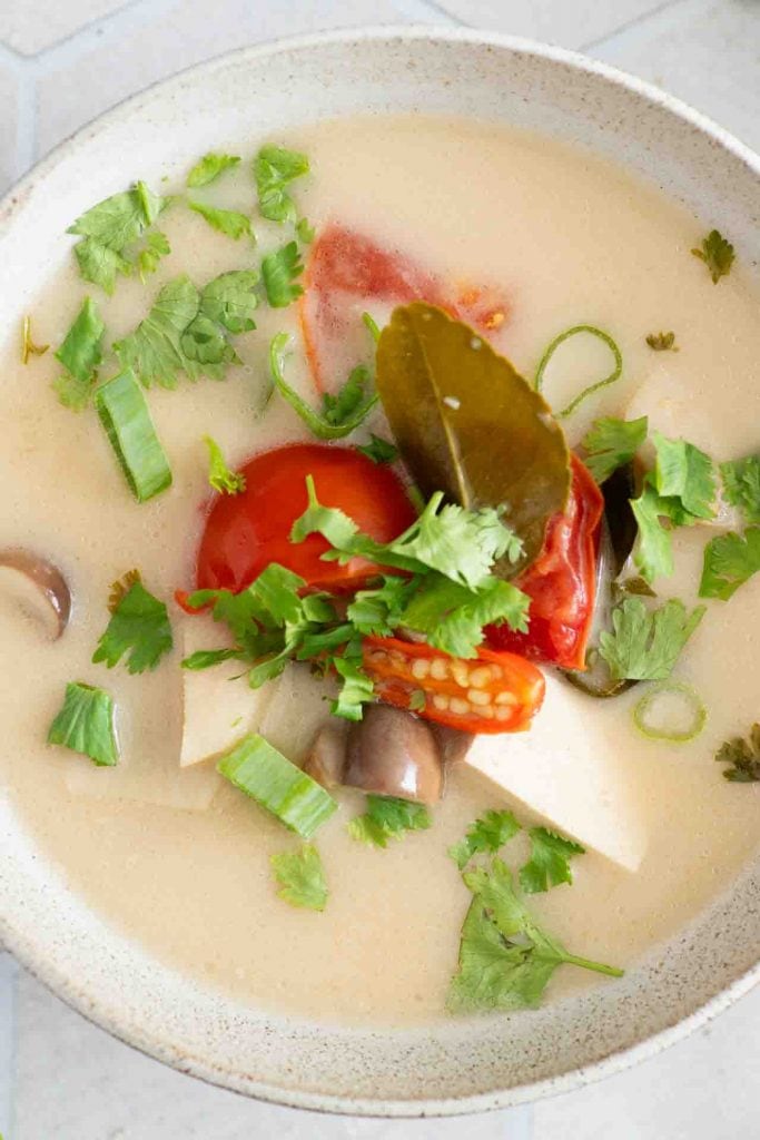 In der Suppe sieht man Tomaten, Pilze und viel grün.