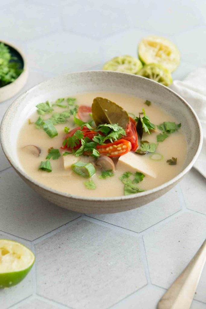 Ein Teller der Tom Kha Gai Suppe auf dem Tisch.