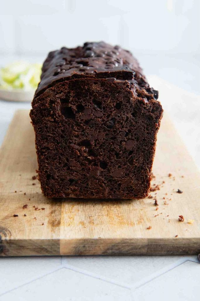 Der Schokokuchen mit Zucchini in der Seitenansicht auf einem Holzbrett.