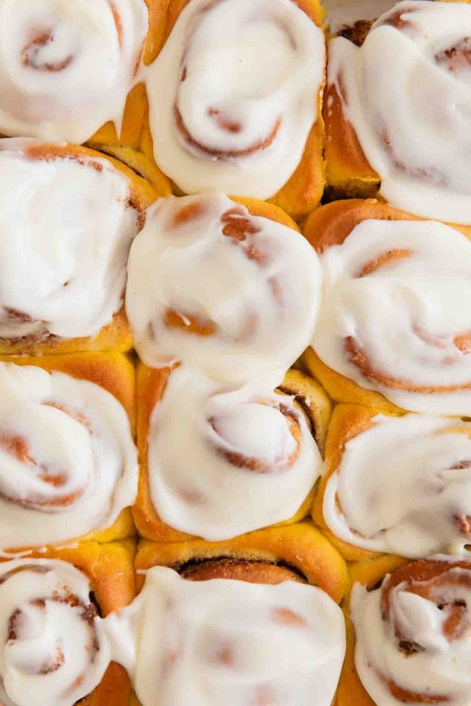 Die Pumpkin Spice Zimtschnecken von oben mit einer weißen Glasur.