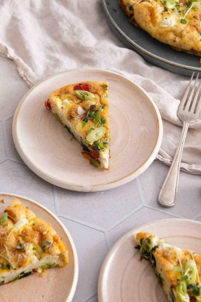 Ein Stück Frittata auf einem Teller mit Gabel.