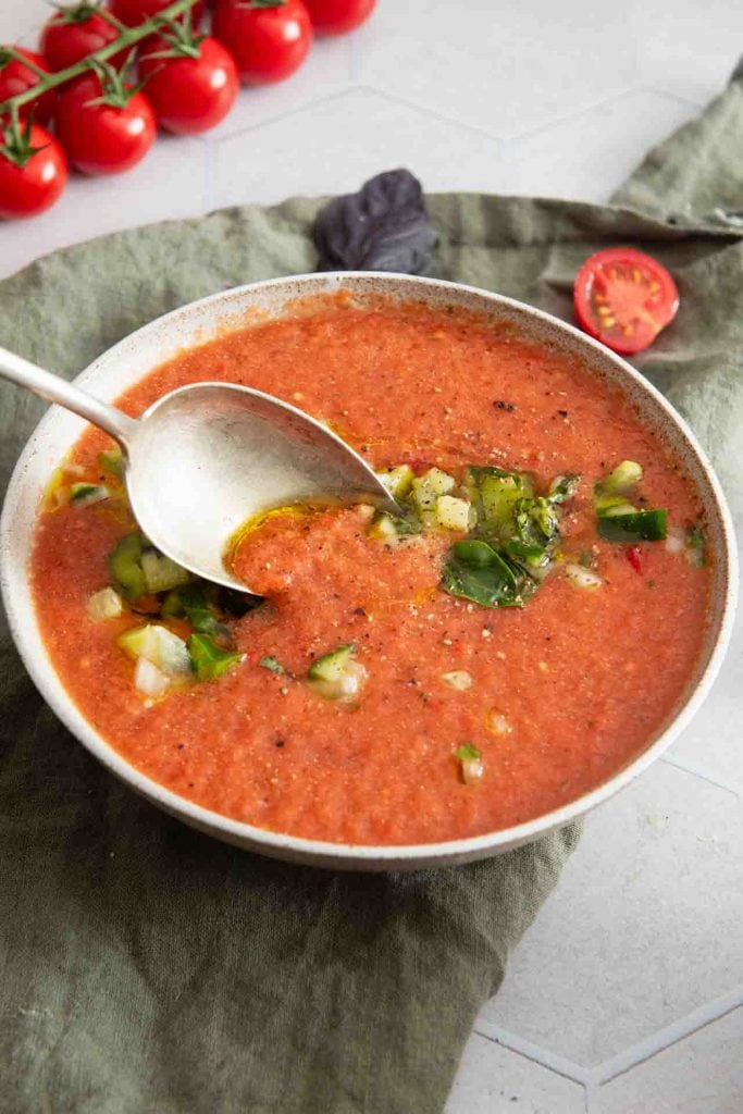 Ein Löfffel nimmt etwas Gazpacho auf.