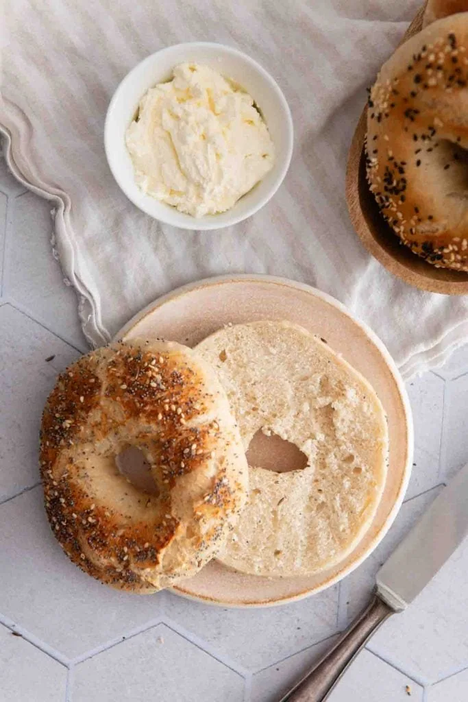 Ein angeschnittener Bagel mit Frischkäsecreme.