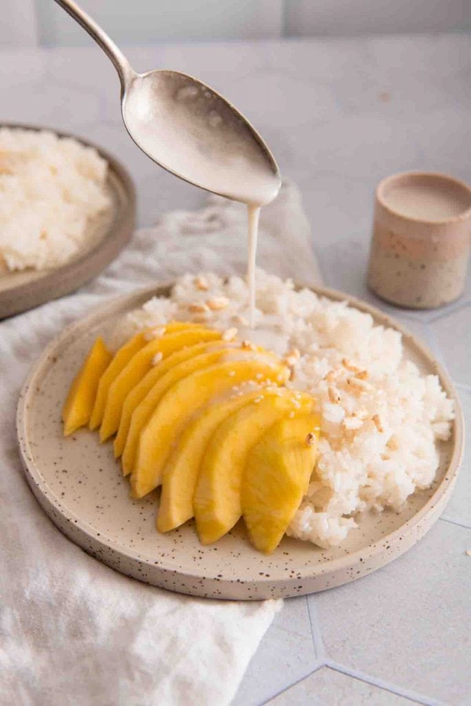 Kokossauce wird über die Mango gegeben