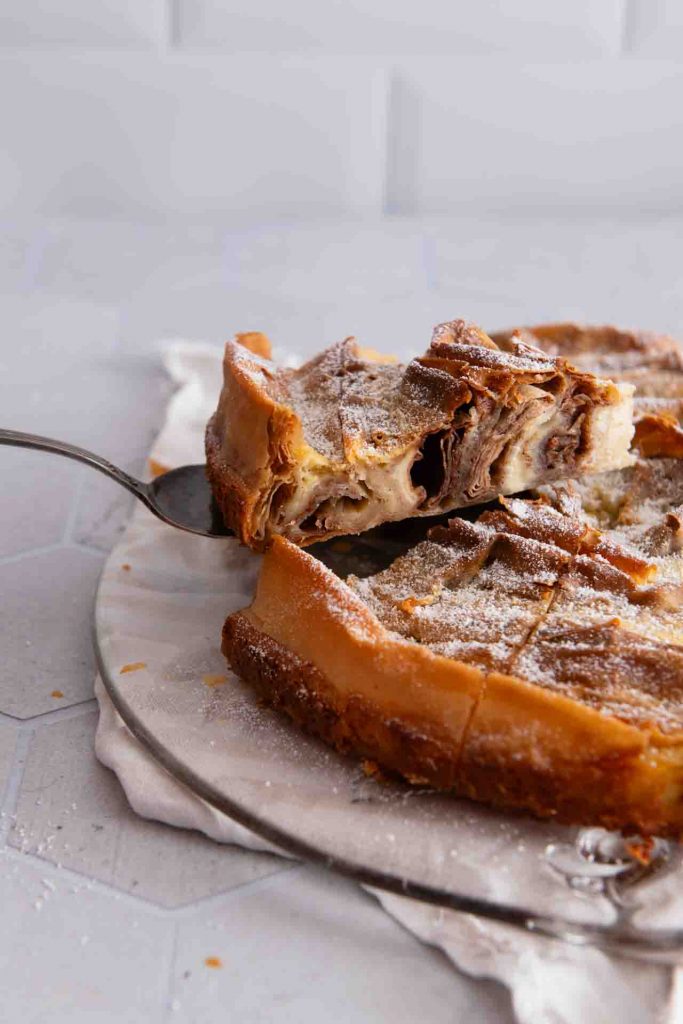 Ein Stück Kuchen mit Filoteig wird mit einer Kuchengabel genommen.