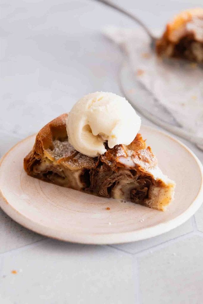 Ein Stück Kuchen mit Filoteig und einer Kugel Vanilleeis.