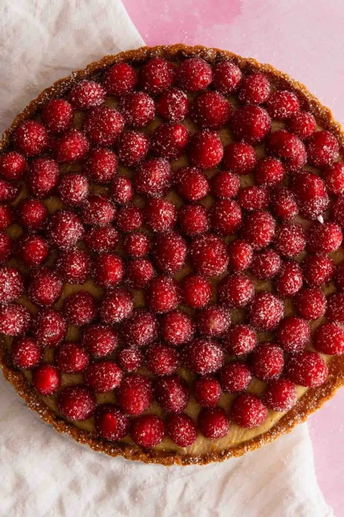 Man sieht die Himbeeren auf einer Tarte von oben.
