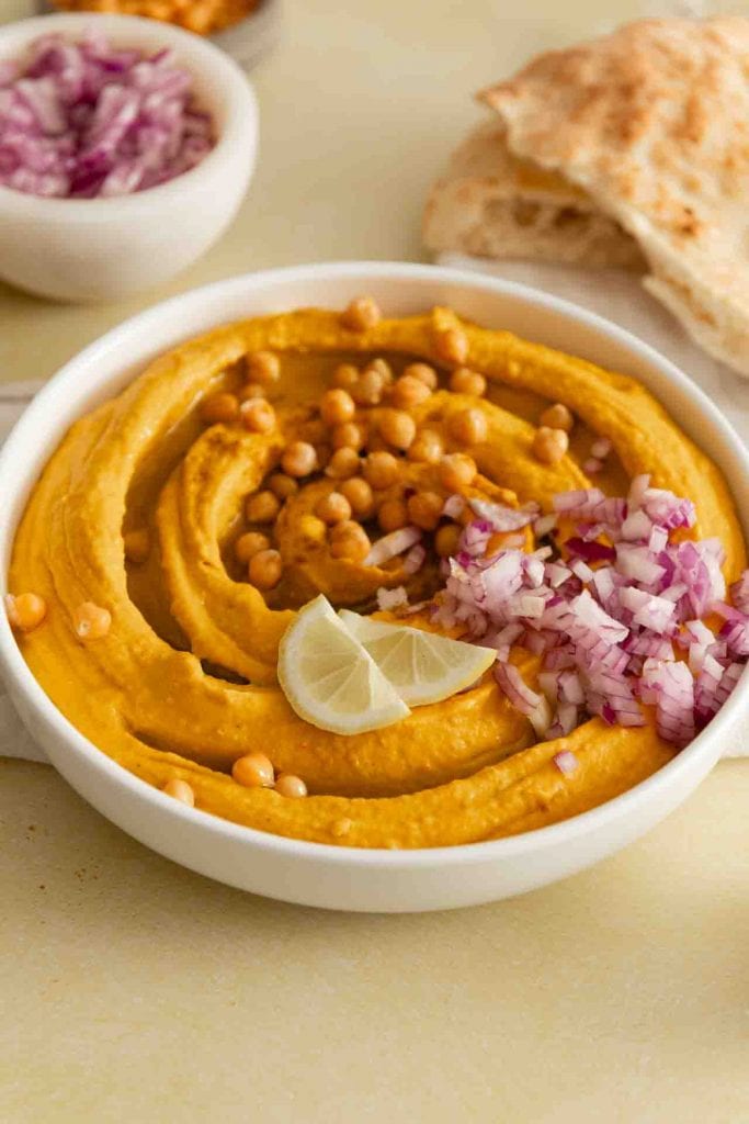 Der Kürbis Hummus mit Kichererbsen, Zitronenscheiben und Zwiebel.