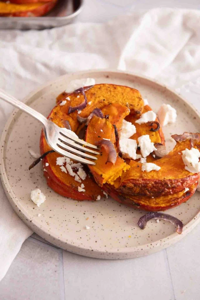 Eine Gabel nimmt etwas Kürbis und Feta auf.