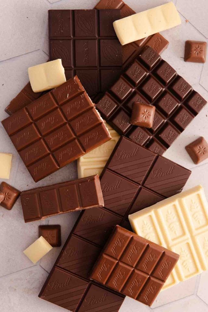 Ganz viel Schokolade auf einem Küchentisch, weiß, vollmilch und Zartbitter.