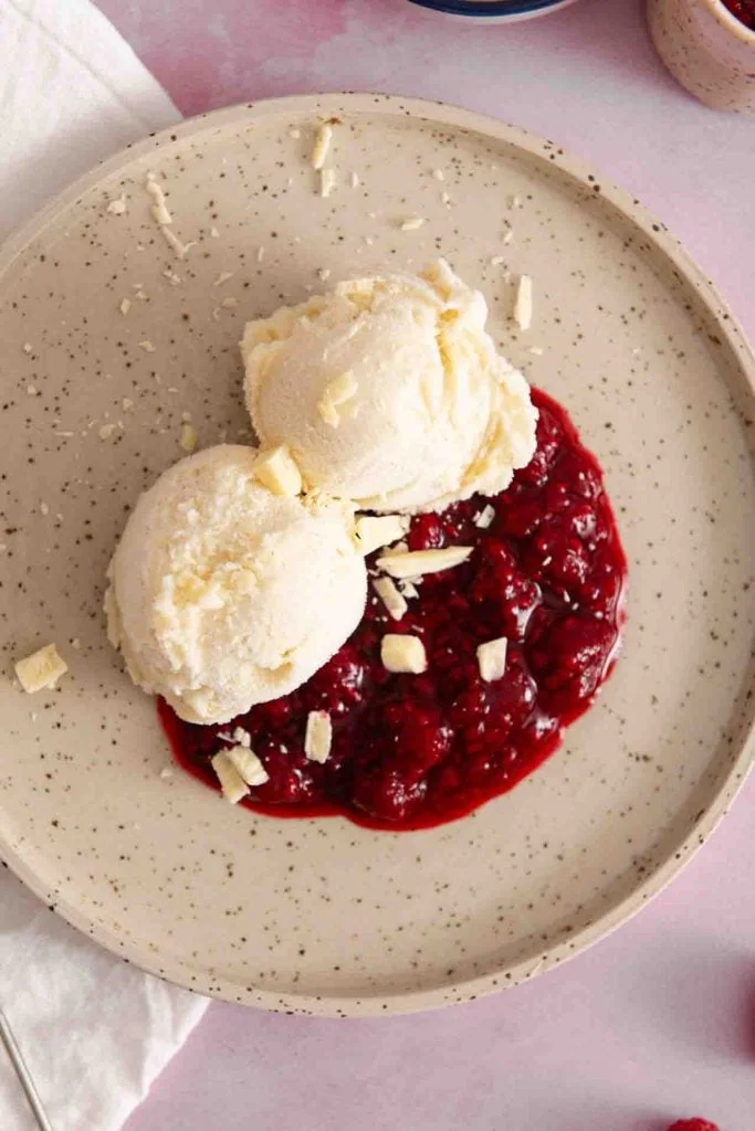 Das Eis und die Himbeeren von oben mit weißer Schokolade.