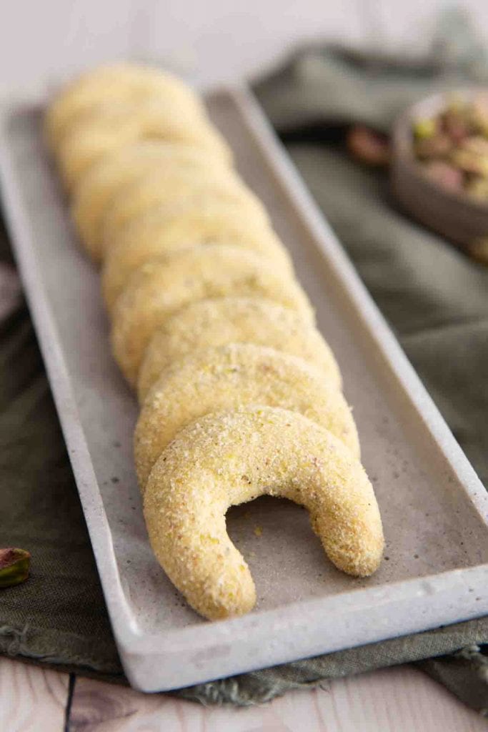 Die Pistazien Kipferl aufgereiht auf einem länglichen Servierteller.