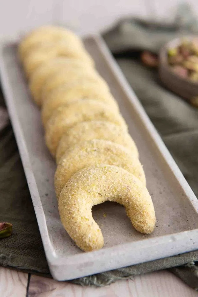 Die Pistazien Kipferl aufgereiht auf einem länglichen Servierteller.