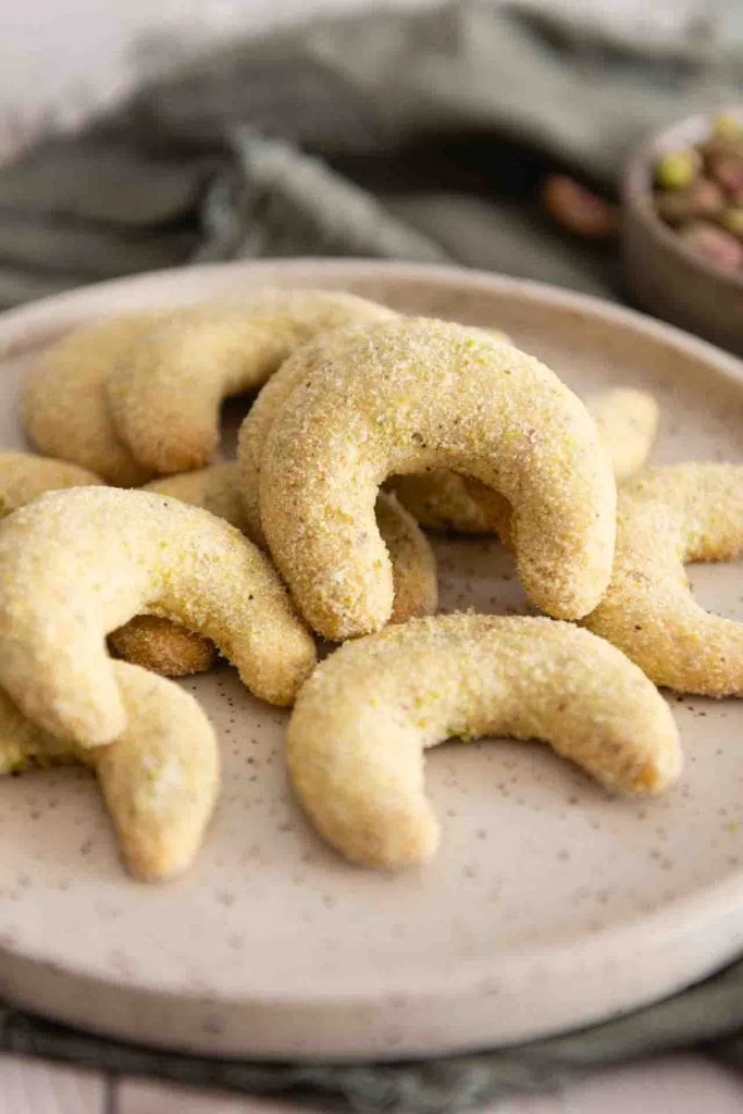 Pistazien Kipferl liegen auf einem Teller.