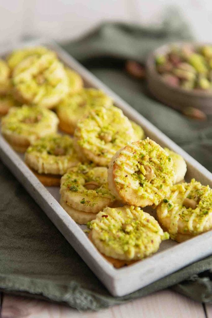 Die Plätzchen mit Pistaziencreme​ liegen auf einem länglichen Teller.