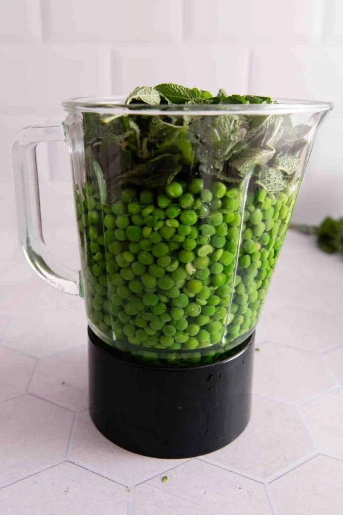 Erbsen und Minze in einem Mixer.