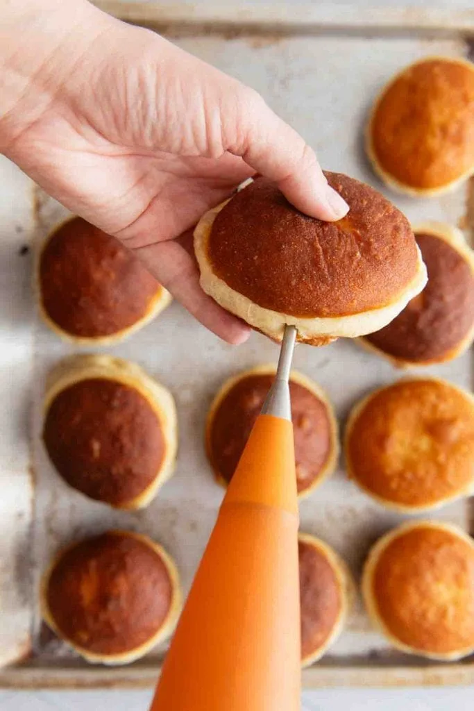 Marmelade in einen Krapfen geben mit einer Spritztülle.