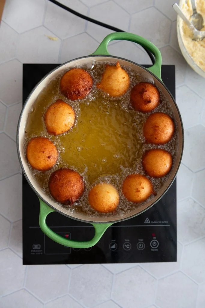 Quarkbällchen backen im heißen Fett. Sie sind goldbraun und das Öl blubbert.