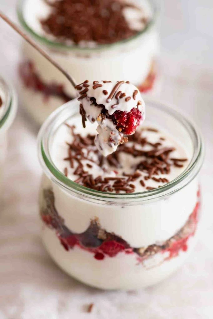 Ein Löffel nimmt etwas von dem Nachtisch auf.