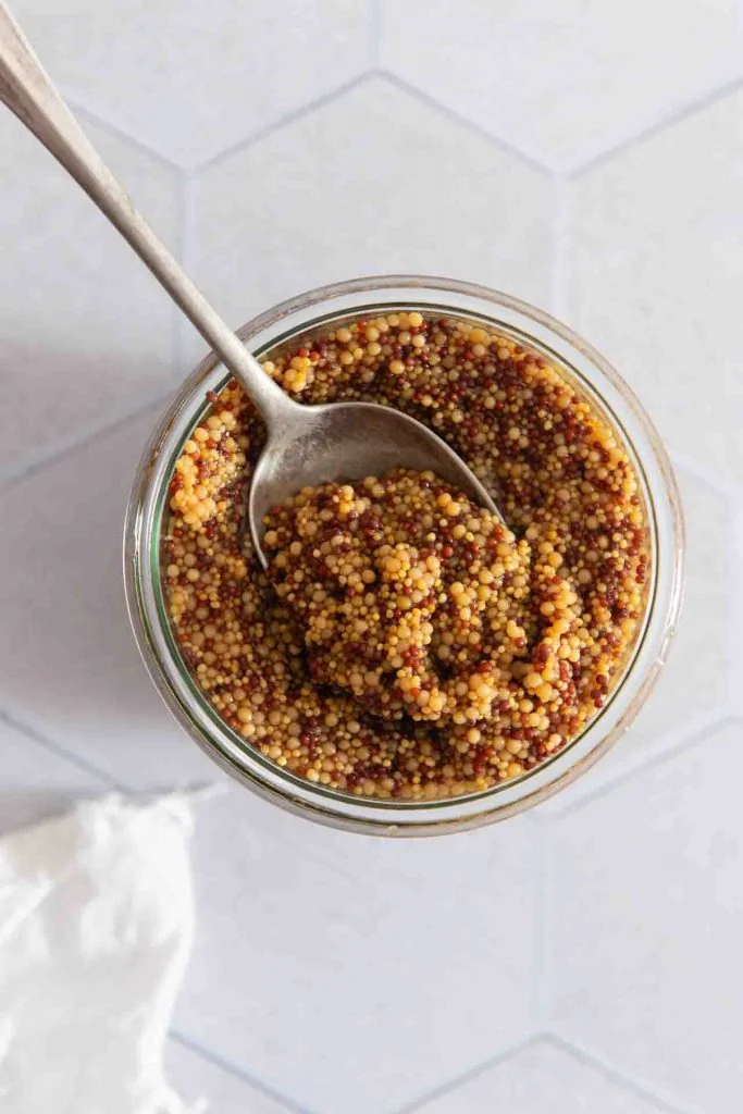 Der Senfkaviar wird von einem Löffel aufgenommen