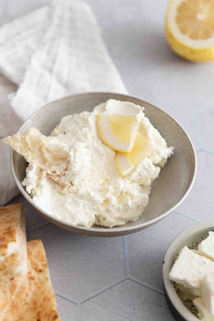Ein Stück Focaccia in dem Feta Dip.