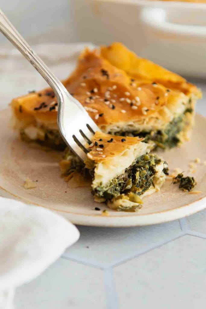 Die Gabel nimmt ein Stück Spanakopita auf.