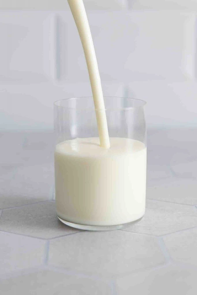 Der Milchkefir wird eingeschenkt in ein Glas.