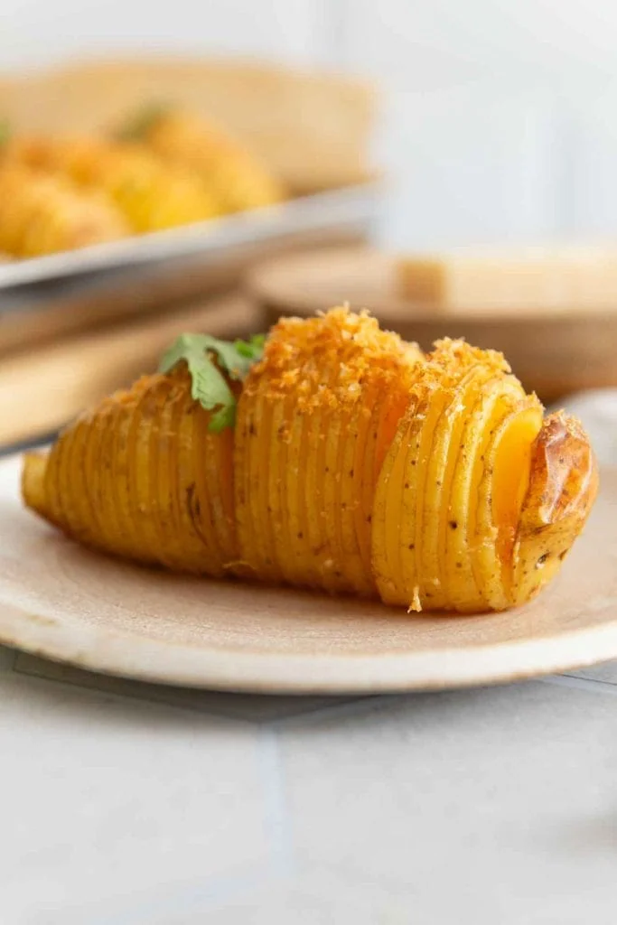 Eine Hasselback Kartoffel auf einem Teller. 