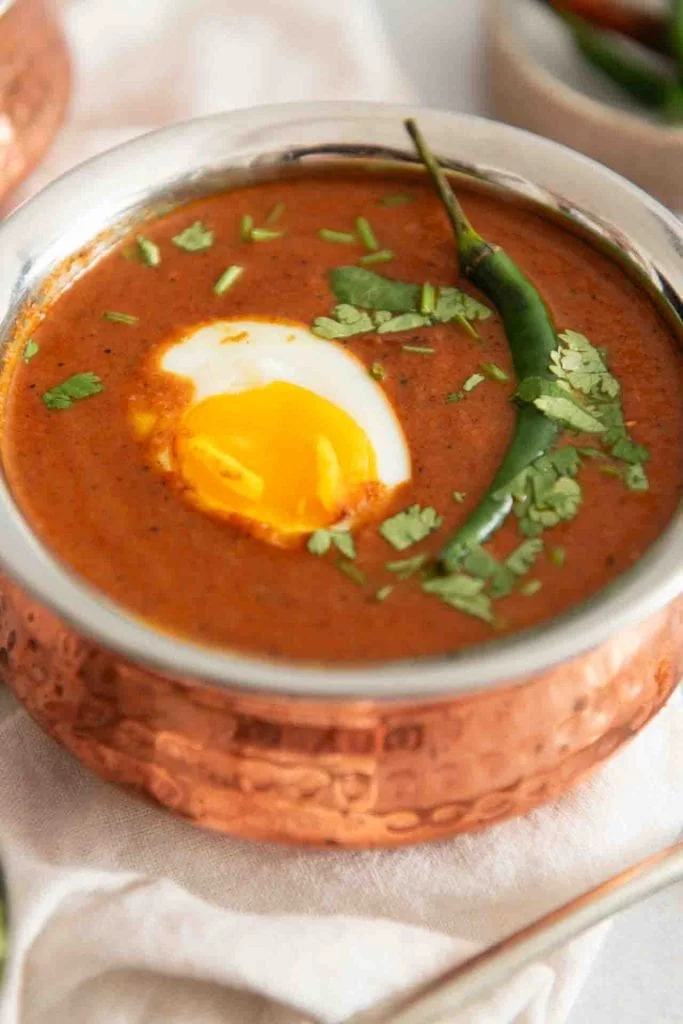 Das Ei und die Chili liegen auf dem Curry.