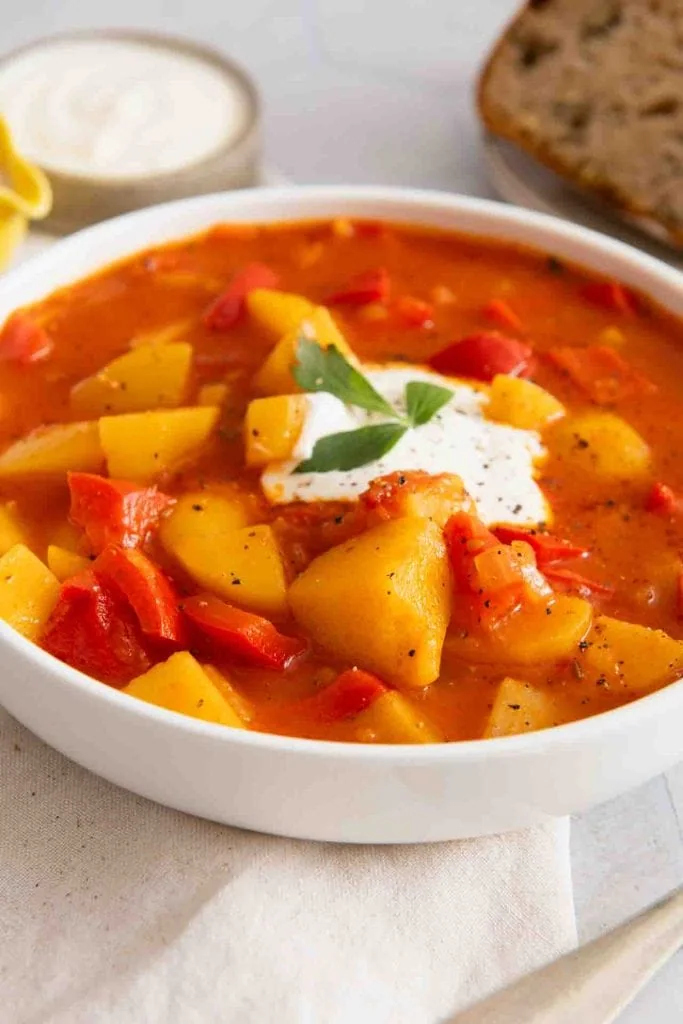 Das vegetarische Gulasch mit Kartoffeln, Paprika und einem Klecks Sauerrahm.