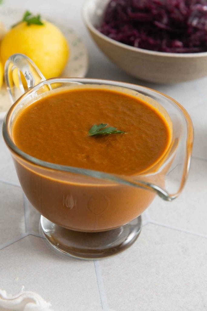 Die vegane Bratensoße in einer Glas-Sauciere.